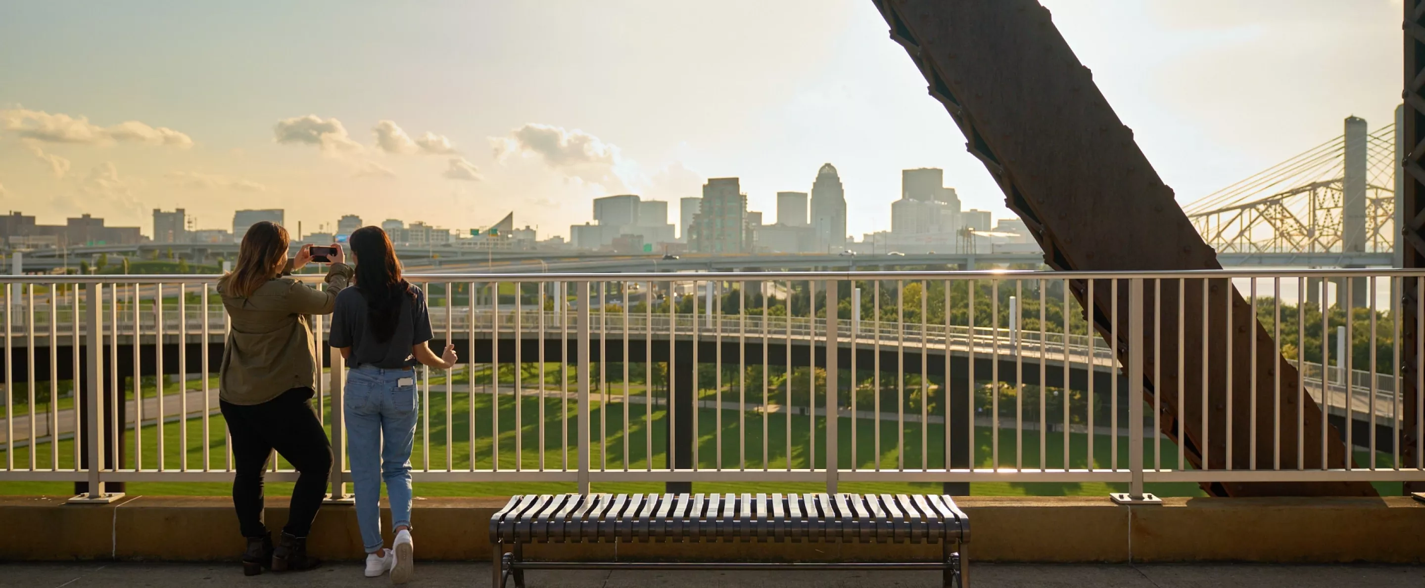 Two students looking at the Louisville skyline from the Big Four Bridge at Waterfront Park in downtown Louisville.