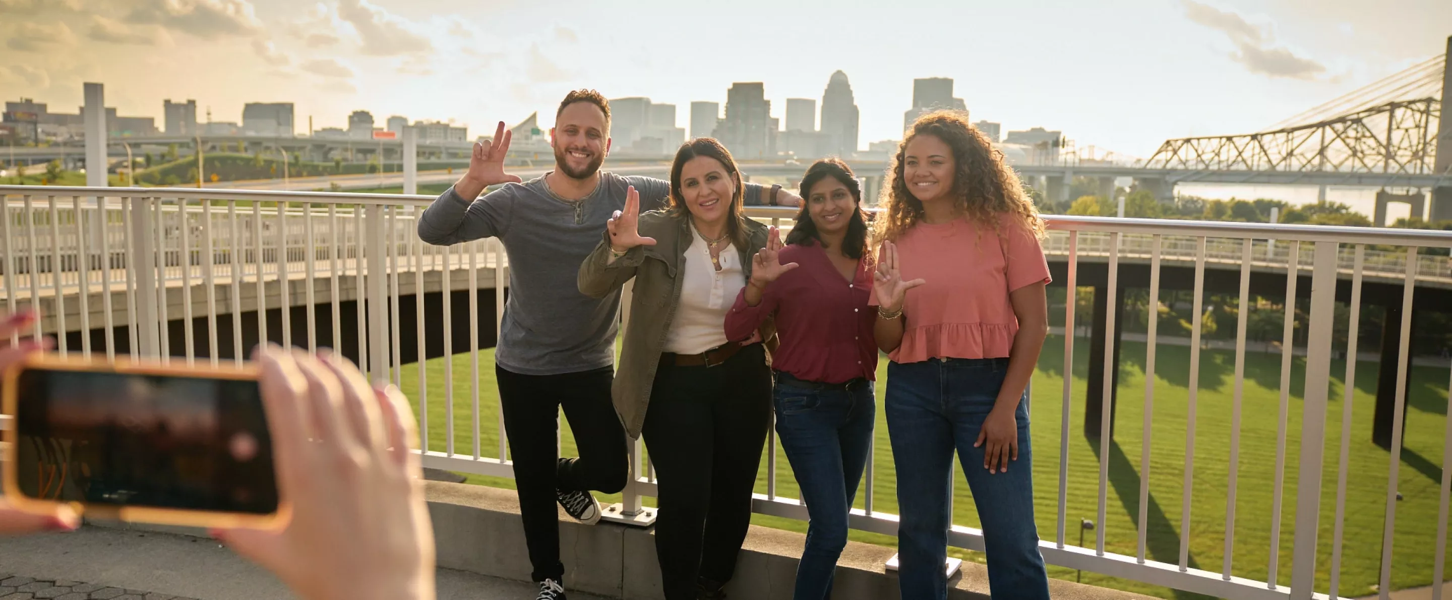Students throwing up their L's for a group photo opportunity at the Big Four Bridge at Waterfront Park in downtown Louisville.