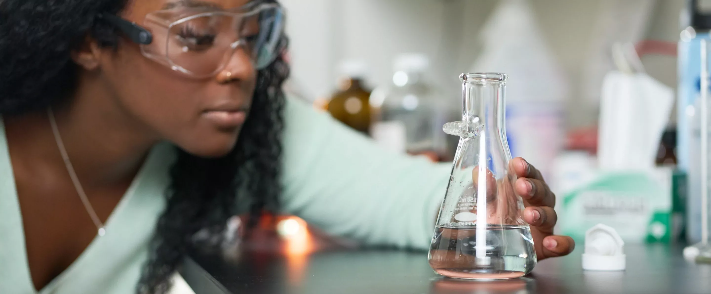Female student performs chemistry experiment in a lab