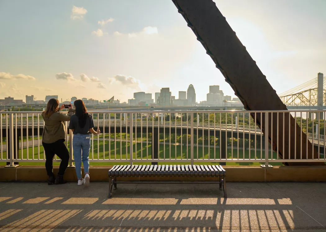 Two students looking at the Louisville skyline from the Big Four Bridge at Waterfront Park in downtown Louisville.
