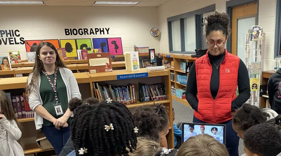 Two college students observing and helping in elementary school.